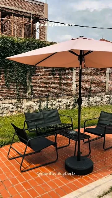Sudut taman dan kursi outdoor MOOT dengan payung, dari profil resmi